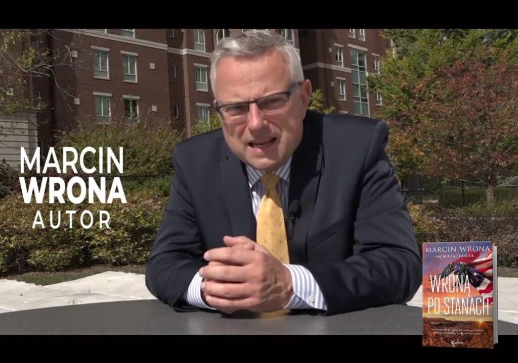 Marcin Wrona relacjonujący na żywo wydarzenie z Waszyngtonu, trzymający mikrofon z logo TVN.