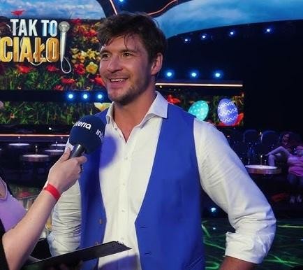 Mikołaj Roznerski relaksujący się w swoim wiejskim domu, otoczony naturą.