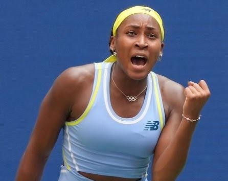 Coco Gauff poza kortem, uśmiechnięta i zrelaksowana, być może podczas spotkania z fanami lub konferencji prasowej, prezentująca swoją przystępną osobowość.
