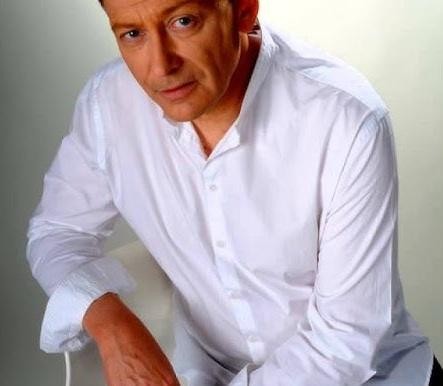 Jacek Borkowski na scenie podczas występu wokalnego lub teatralnego.