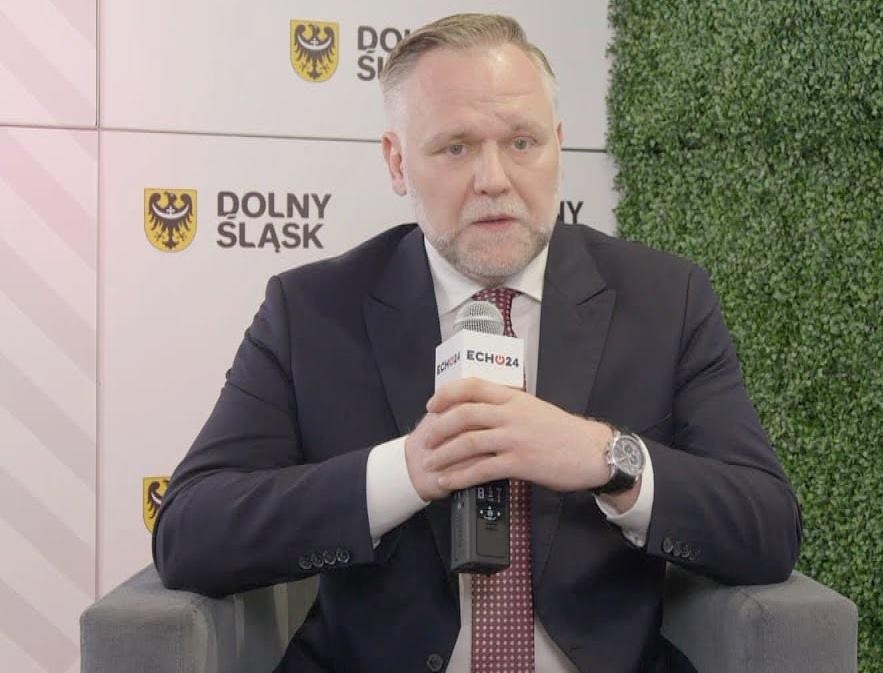 Dawid Jackiewicz podczas wystąpienia publicznego, prezentujący doświadczenie i zaangażowanie.