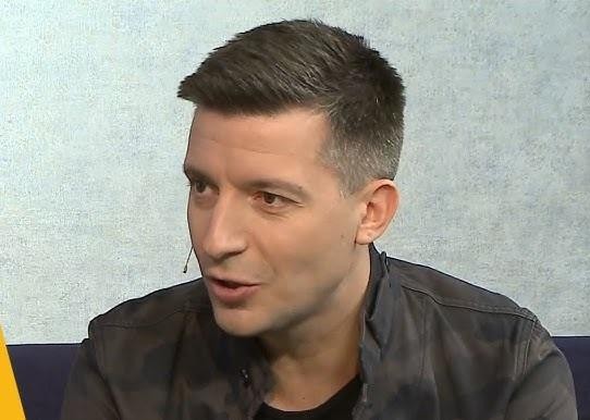 Michał Cessanis w trakcie pracy jako dziennikarz podróżniczy, w egzotycznym otoczeniu, z aparatem w ręku.