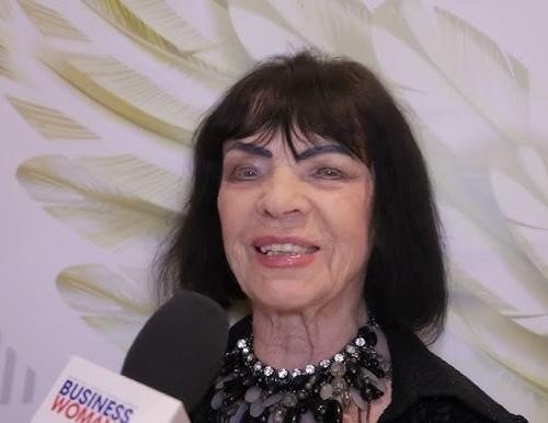 Sława Przybylska na scenie, śpiewająca do mikrofonu, w stylizacji retro, z tłem sugerującym dawny teatr.