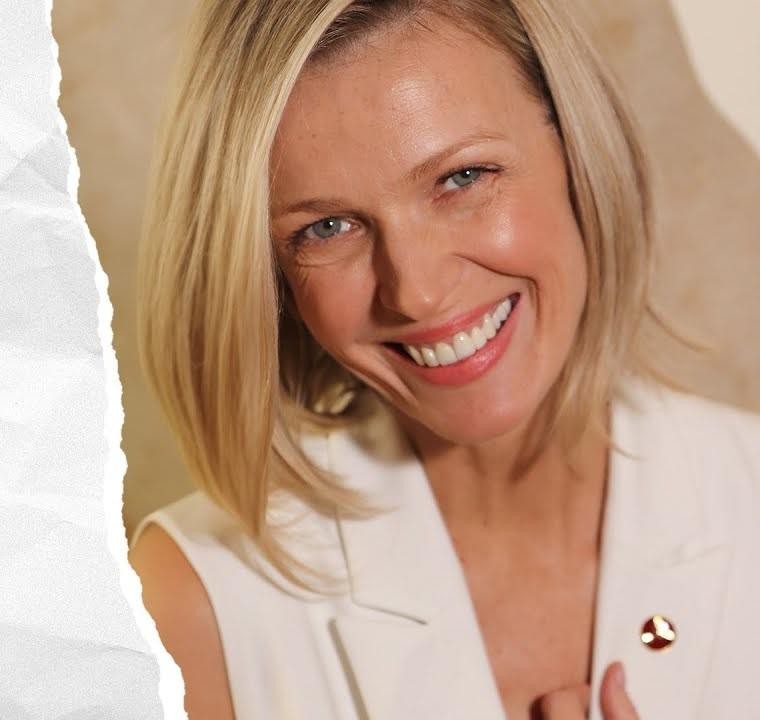Magda Mołek w studiu telewizyjnym, uśmiechnięta i pełna energii, w profesjonalnym stroju, symbolizującym jej karierę prezenterki.