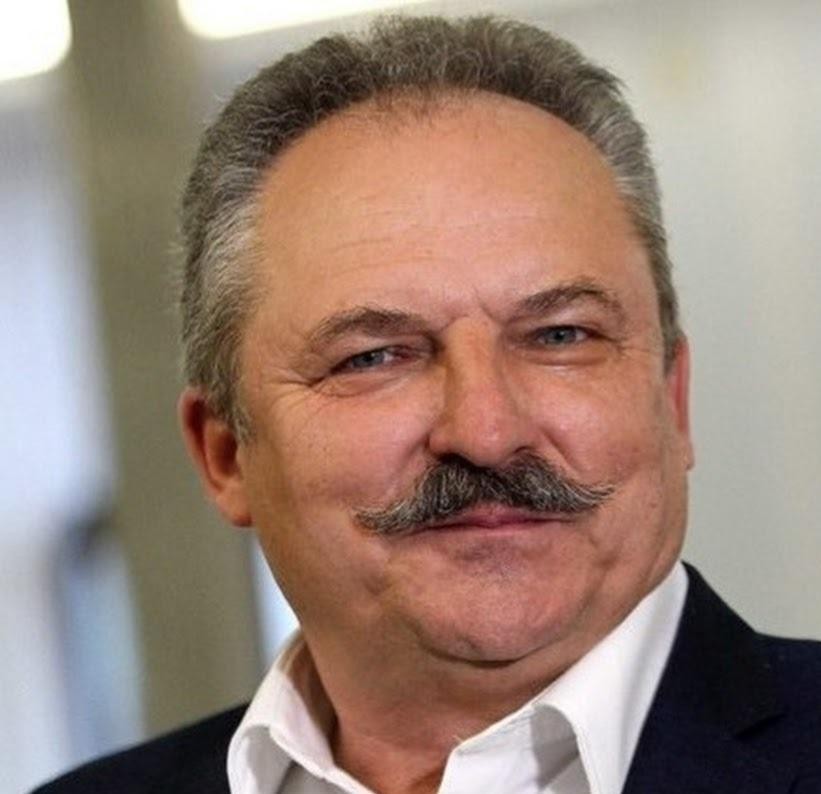 Marek Jakubiak podczas wystąpienia publicznego, z mikrofonem w ręku, przemawiający do publiczności.