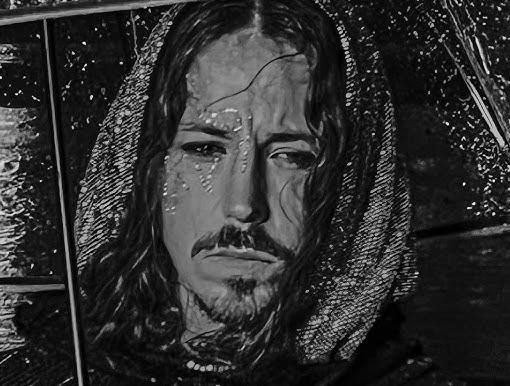 Michał Szpak na scenie podczas koncertu, w dynamicznej pozie, z rozwianymi włosami i w oryginalnym stroju, otoczony przez światła sceniczne.
