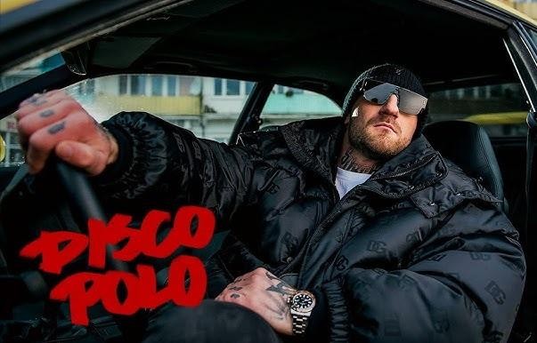 Kizo (Patryk Woziński) na tle mediów społecznościowych, symbolizujący jego interakcje z fanami i dużą obecność w sieci, z elementami Instagrama.