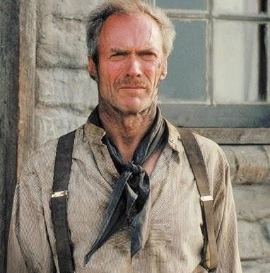 Clint Eastwood w stroju kowboja z westernu, z intensywnym spojrzeniem, na tle pustynnego krajobrazu.