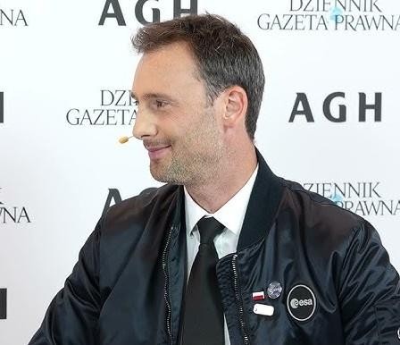 Sławosz Uznański uśmiechnięty, w interakcji z publicznością, symbolizujący jego otwartość i aktywność na Instagramie.